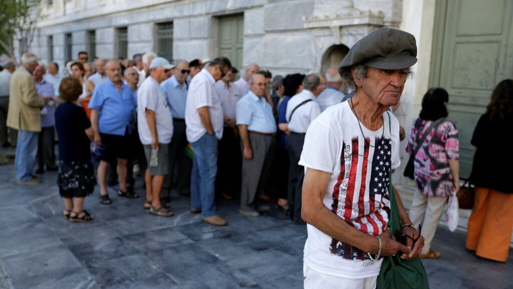 Människor köar utanför den grekiska centralbanken. Under juli, 2015, infördes en rad restriktioner som slog hårt mot hushållen, bland annat begränsning av uttag av kontanter.